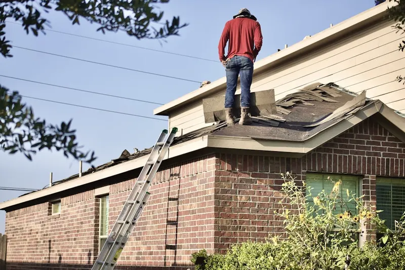 Professional roofer working on a residential roof in McDonald